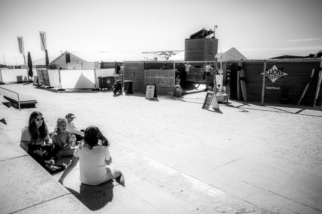 Shoreline with waves and distant walkers at The Shore Scheveningen