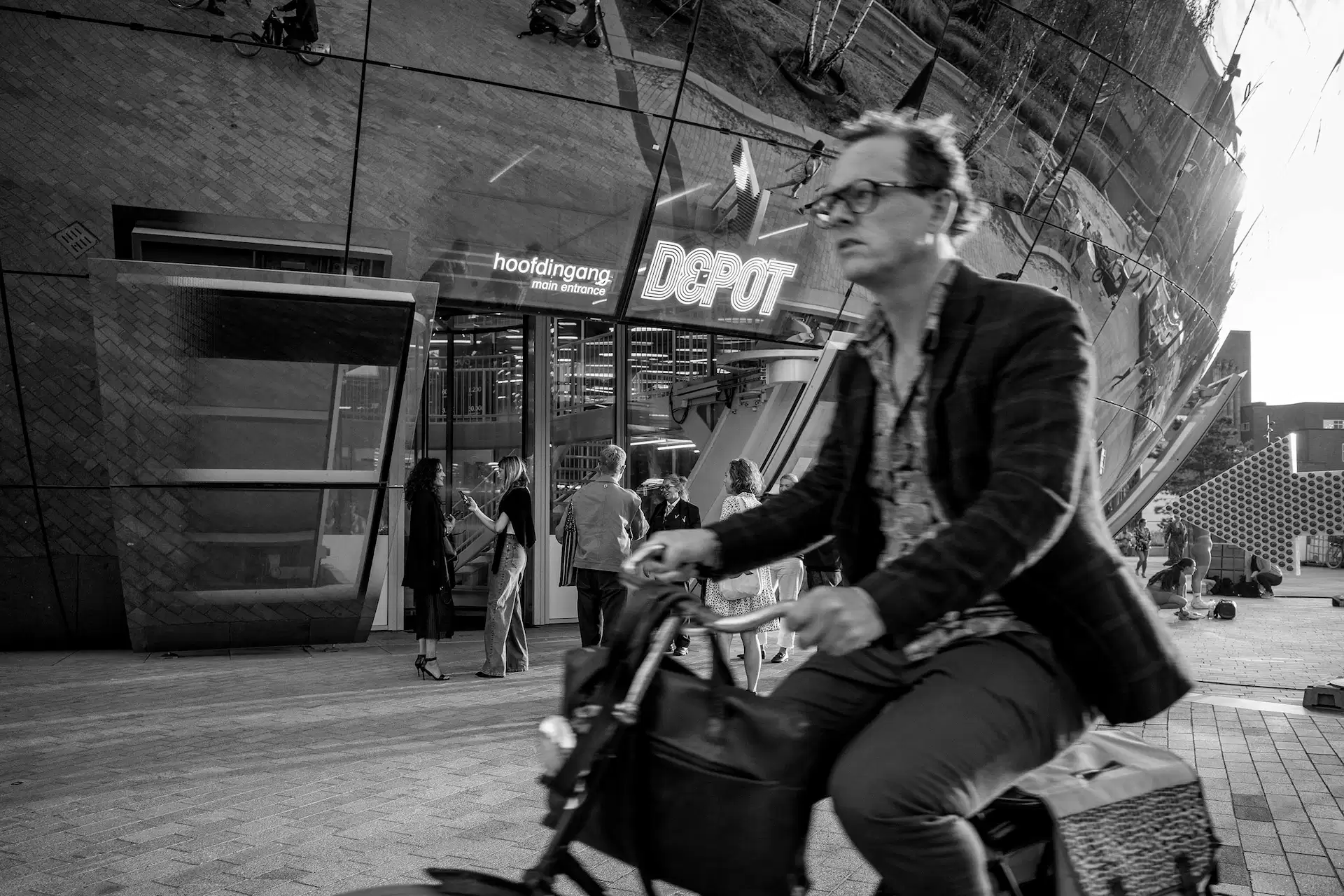 Cyclist passing the main entrance of the Depot of Museum Boijmans Van Beuningen, Rotterdam.
