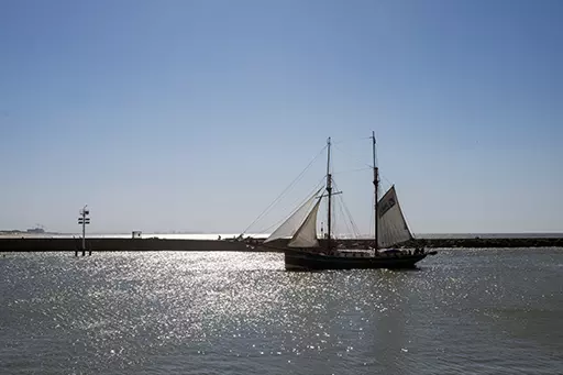 Sailing ship near the Southern Harbor Head Scheveningen in bright sunlight